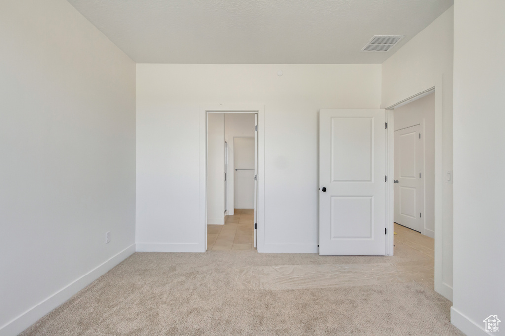 Unfurnished bedroom featuring light colored carpet