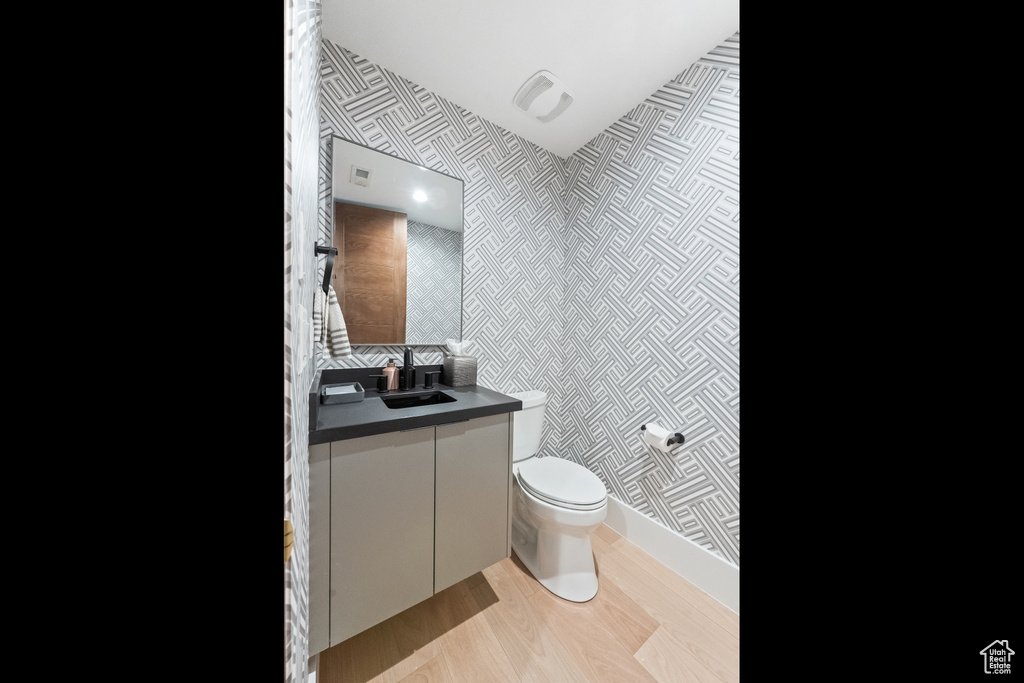 Bathroom featuring tile walls, toilet, and vanity