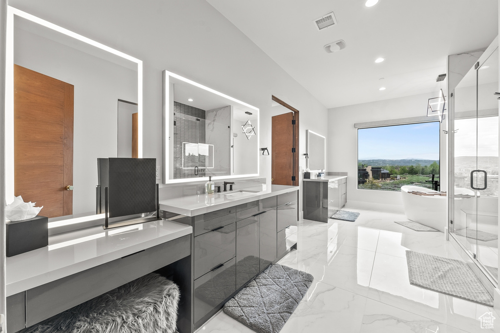 Bathroom featuring tile patterned floors, vanity, and separate shower and tub