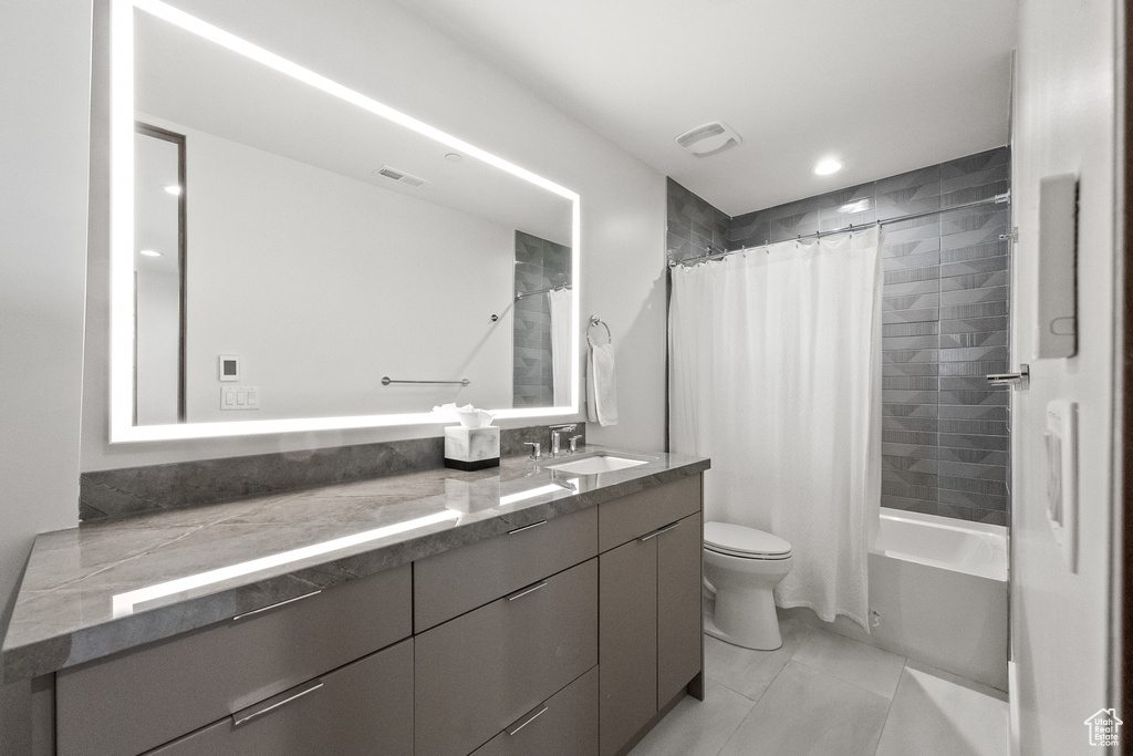 Full bathroom with shower / bathtub combination with curtain, toilet, vanity, and tile patterned flooring