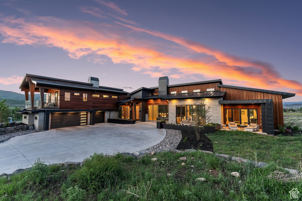 Back house at dusk with a yard and a garage