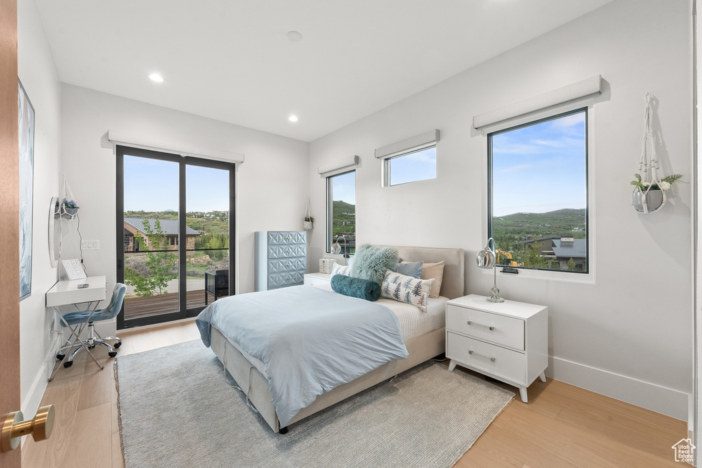 Bedroom with access to exterior and light hardwood / wood-style floors