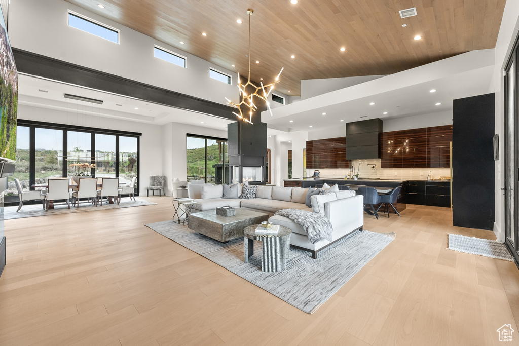 Living room featuring a towering ceiling, wood ceiling, and light hardwood / wood-style floors