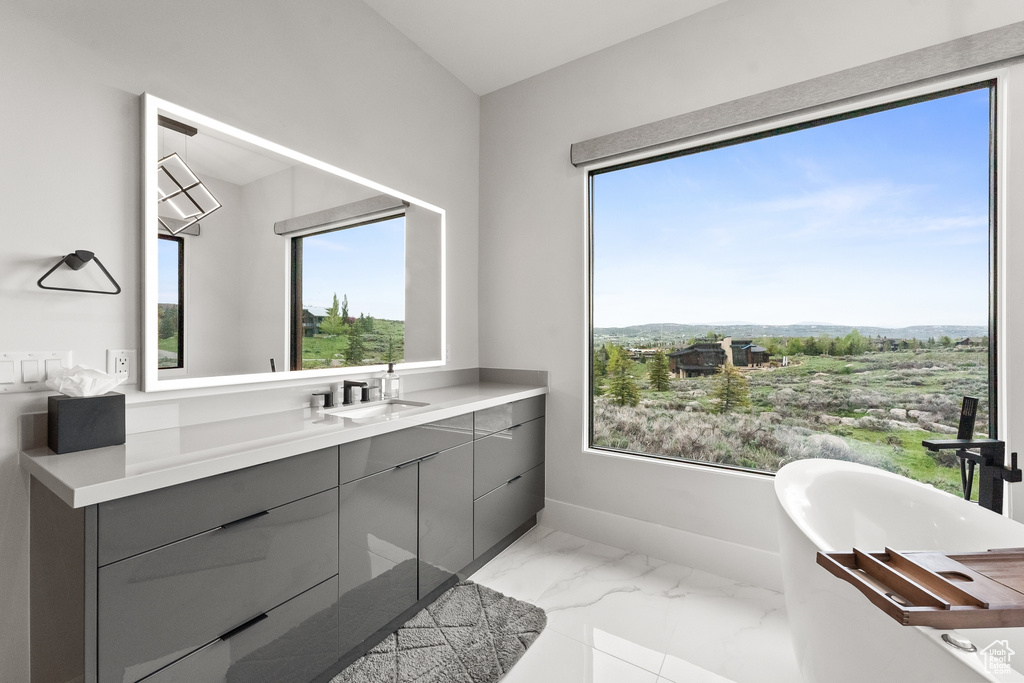 Bathroom featuring tile patterned floors, vanity, and a wealth of natural light