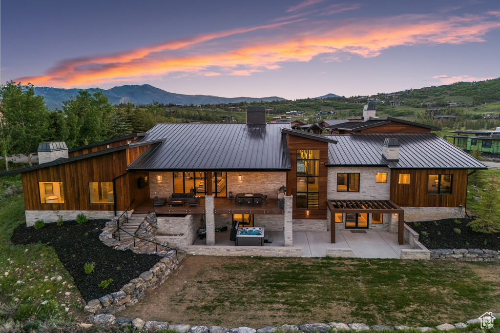 Back house at dusk with a patio and a mountain view