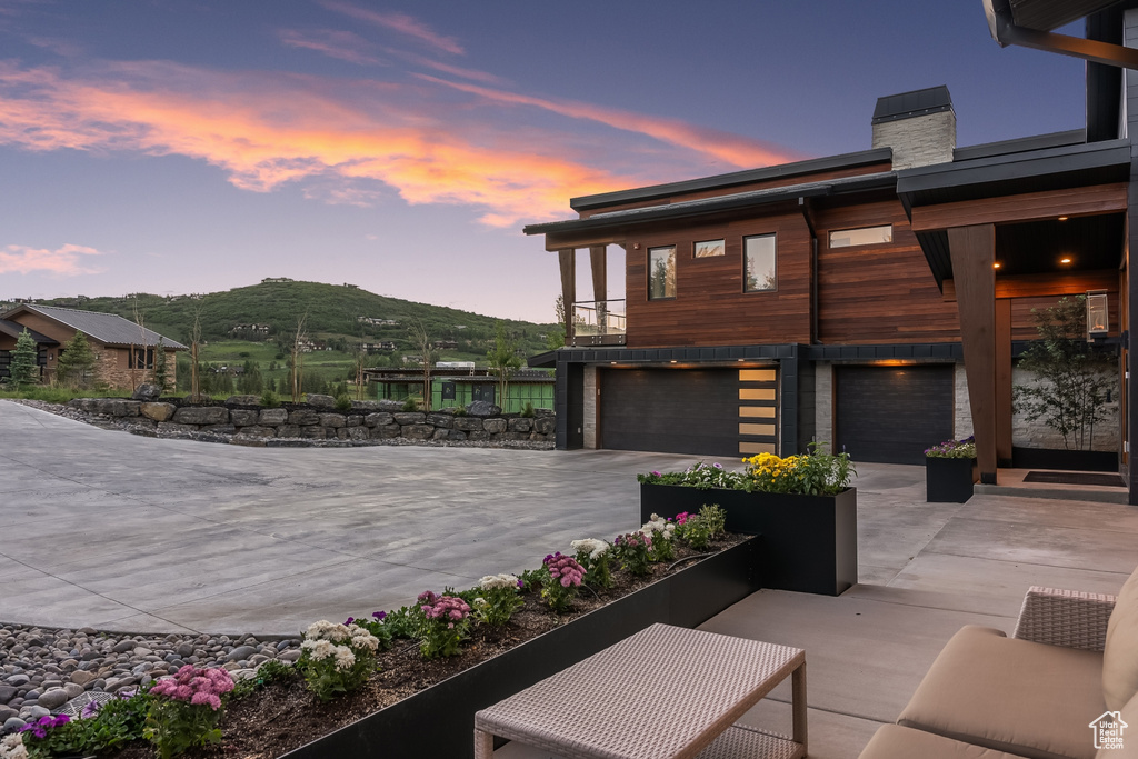 Patio terrace at dusk with a mountain view and a garage