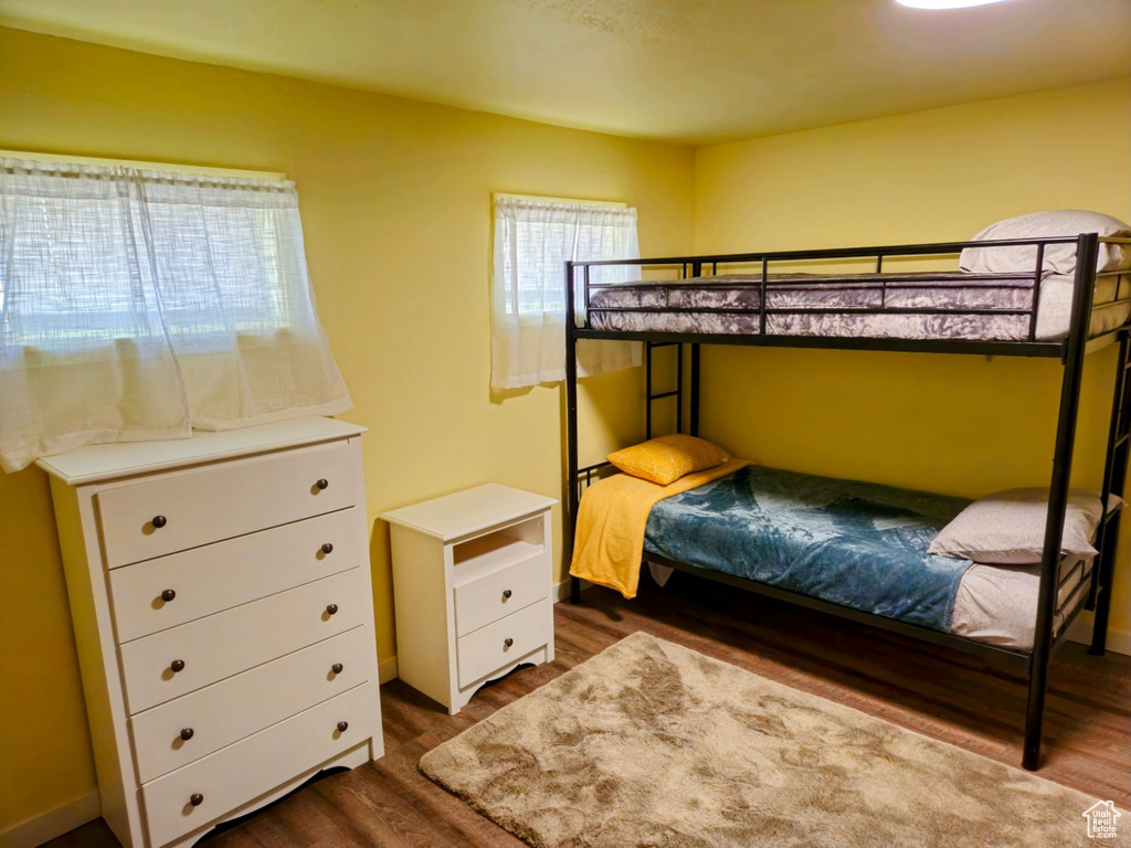 Bedroom with dark hardwood / wood-style flooring