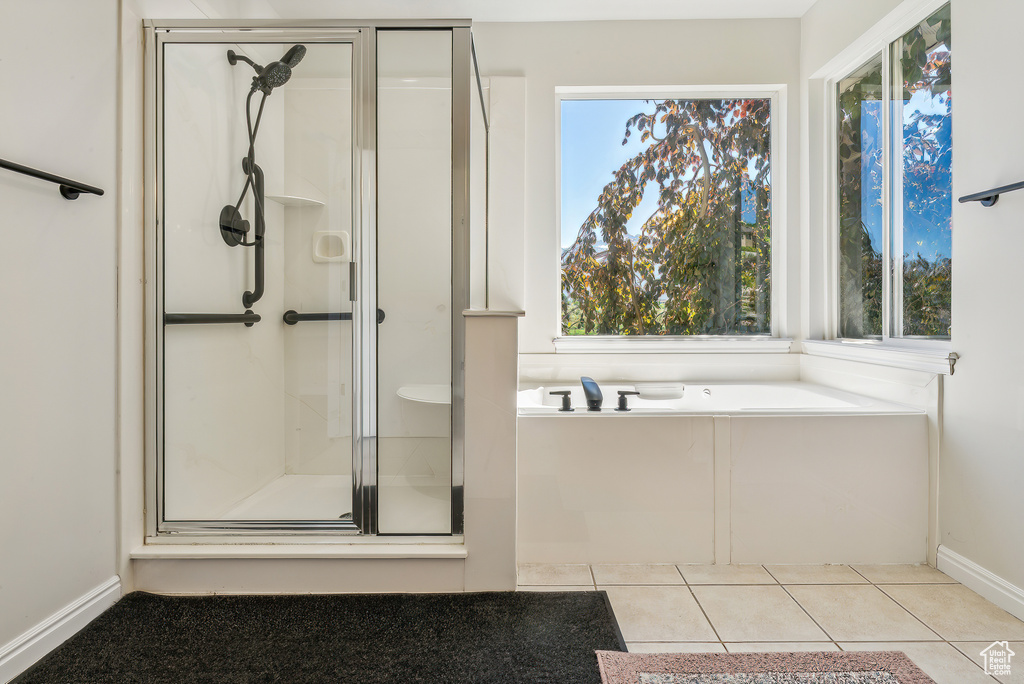 Bathroom with shower with separate bathtub and tile flooring