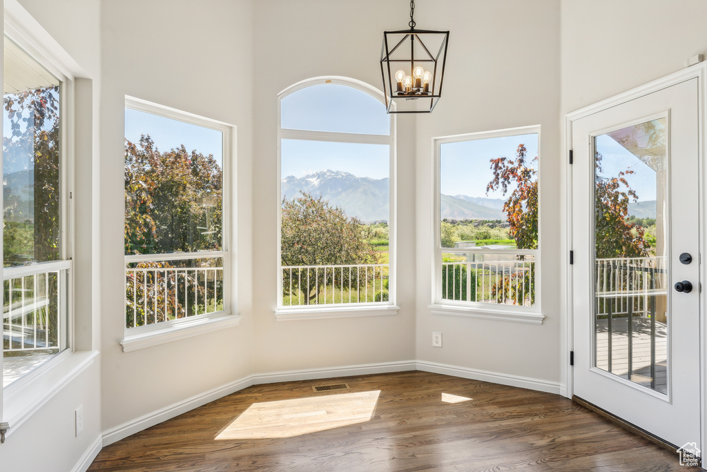 Unfurnished sunroom with a mountain view and an inviting chandelier