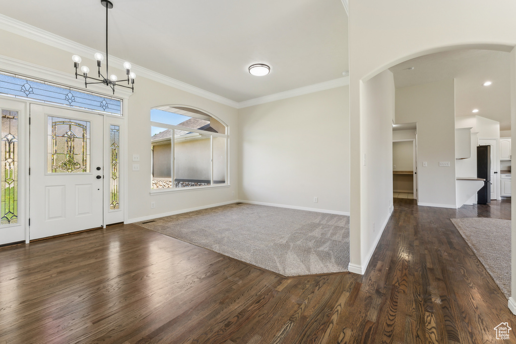 Foyer featuring ornamental molding, dark hardwood / wood-style floors, and an inviting chandelier