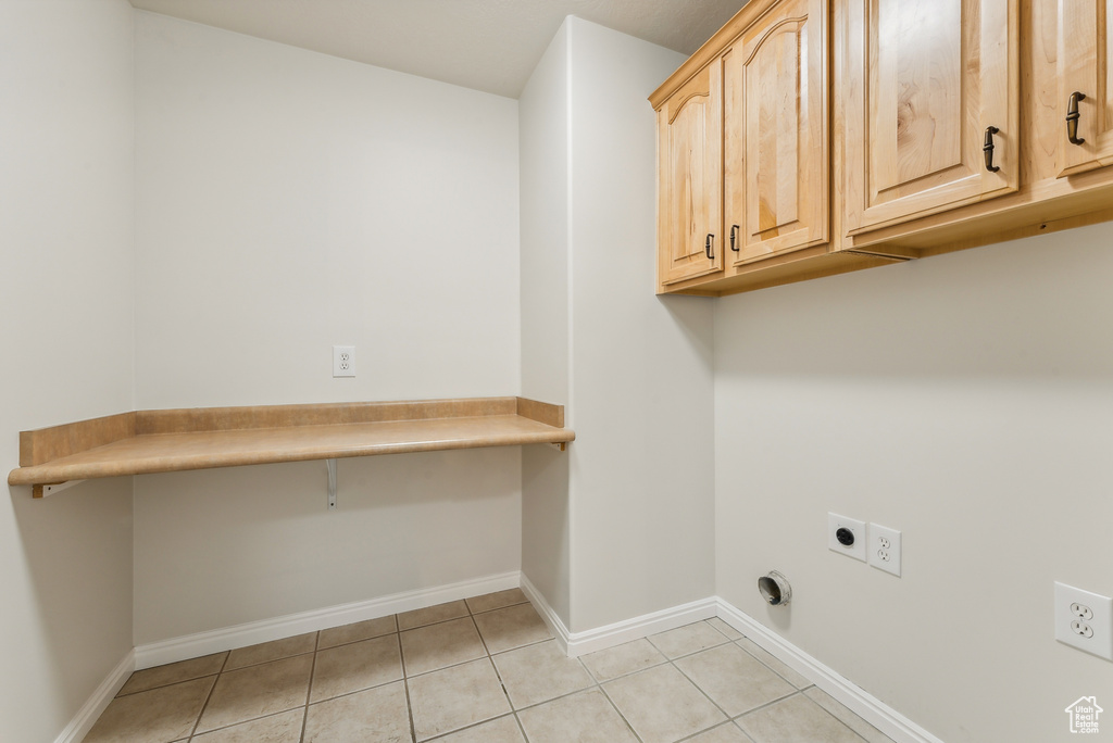 Washroom with cabinets, hookup for an electric dryer, and light tile floors