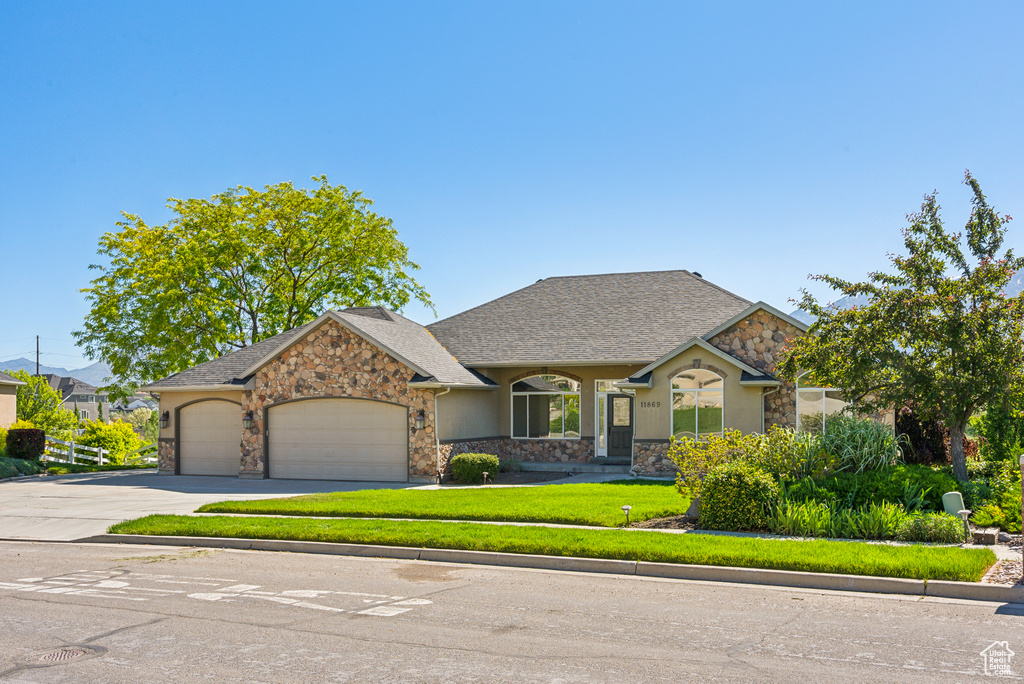 View of front facade featuring a garage and a front yard