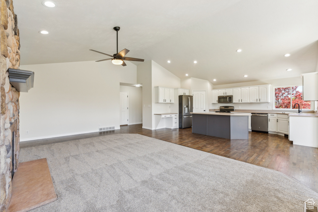 Kitchen featuring a kitchen island, ceiling fan, dark wood-type flooring, white cabinets, and appliances with stainless steel finishes