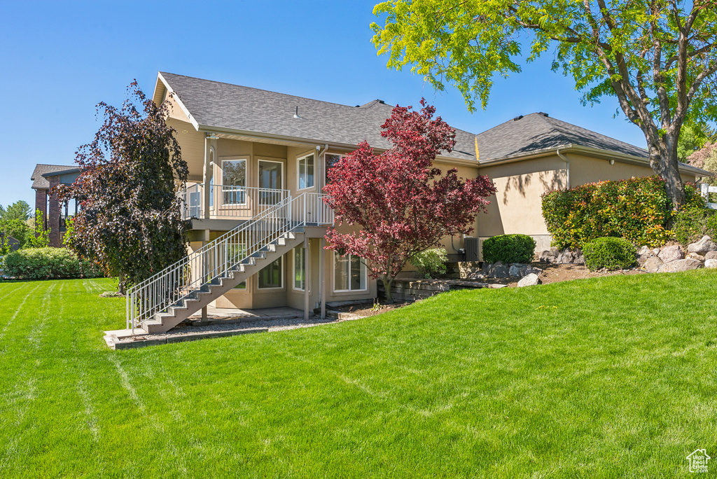 Rear view of house featuring a yard