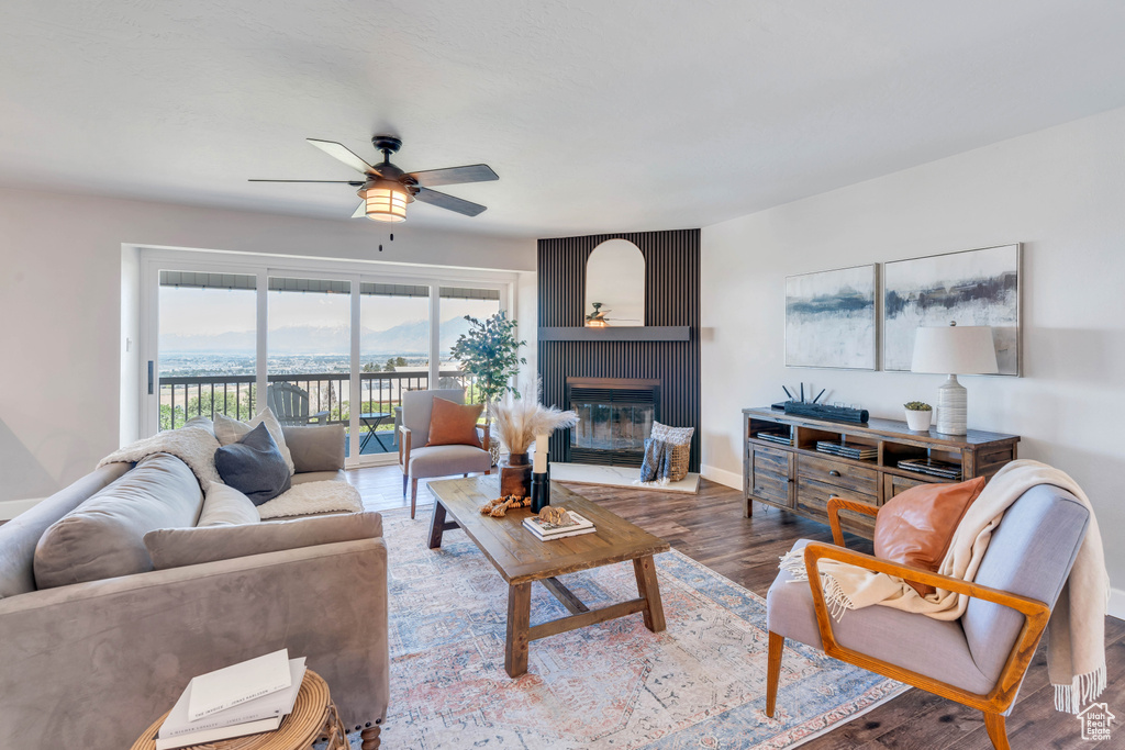 Living room featuring a fireplace, ceiling fan, and hardwood / wood-style floors