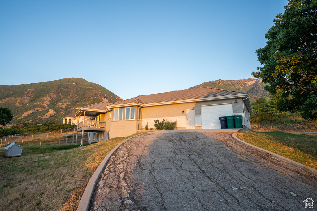 View of front of house with a front lawn, a garage, and a mountain view