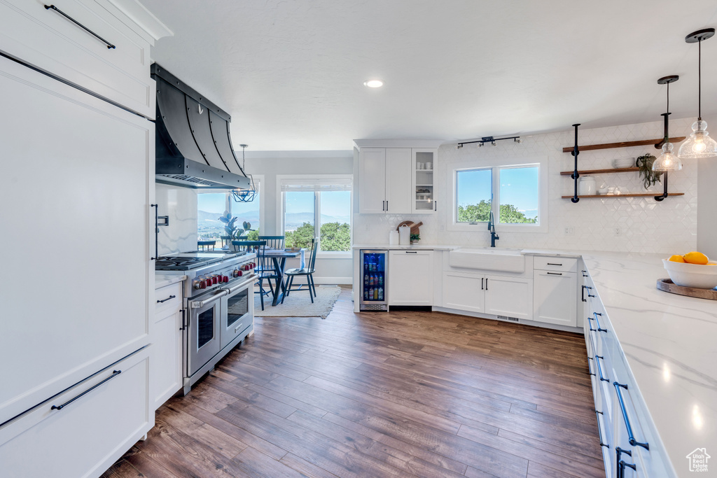 Kitchen with double oven range, sink, dark hardwood / wood-style floors, and backsplash