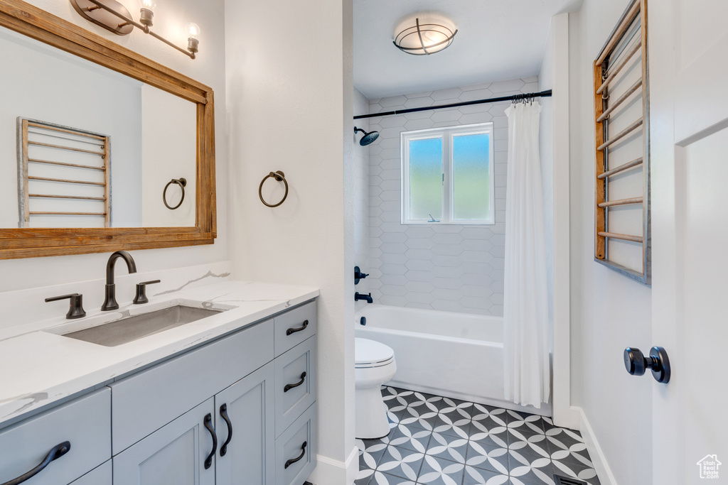 Full bathroom featuring tile floors, shower / bath combo, toilet, and vanity