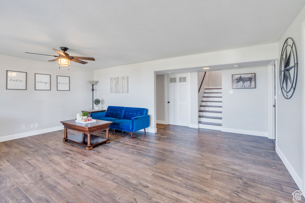 Living room featuring dark wood-type flooring and ceiling fan