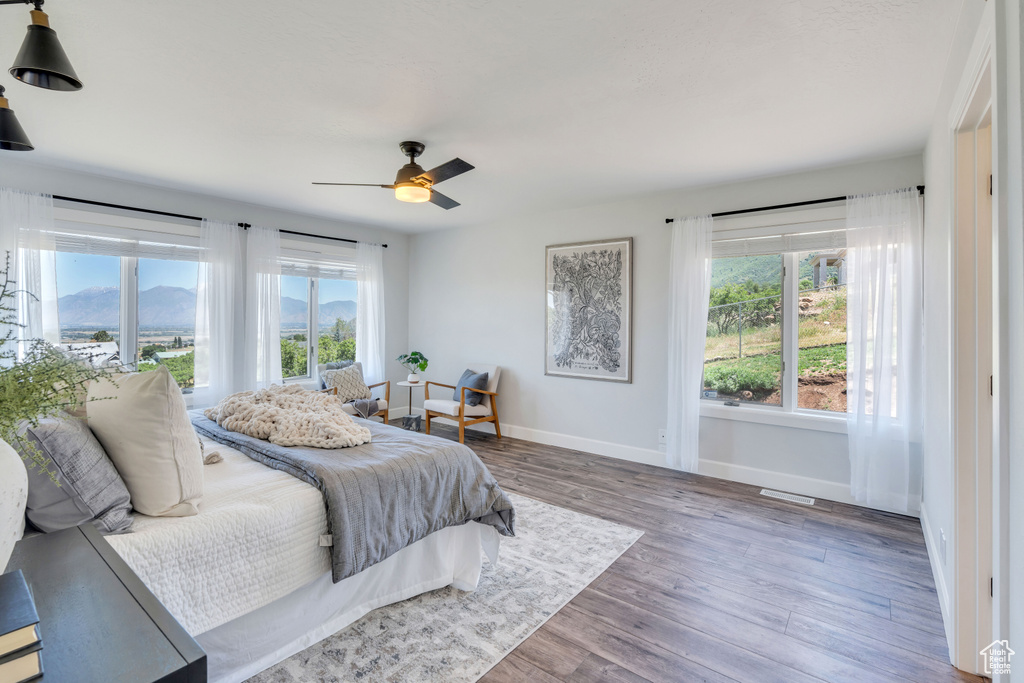 Bedroom featuring ceiling fan, a mountain view, and wood-type flooring