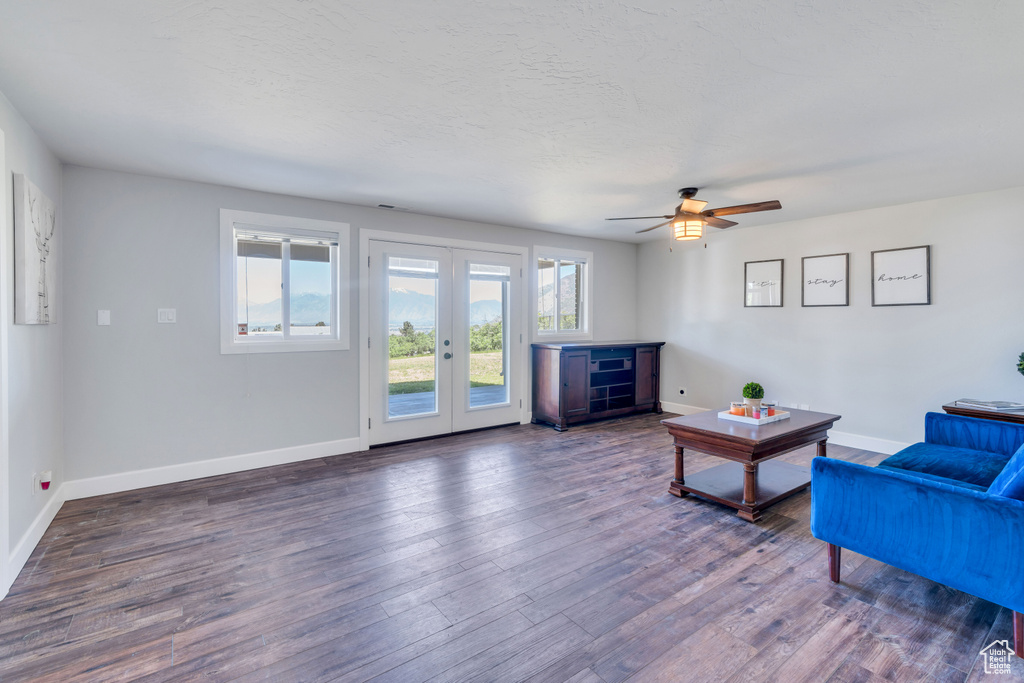 Living room with dark hardwood / wood-style flooring, ceiling fan, and french doors