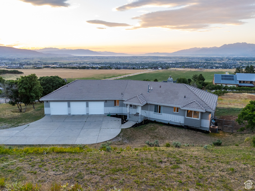 View of front facade featuring a garage, a mountain view, and an outdoor structure