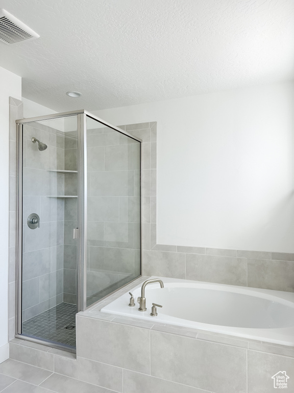 Bathroom featuring a textured ceiling, independent shower and bath, and tile patterned floors