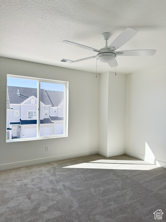 Spare room with carpet, a textured ceiling, and ceiling fan