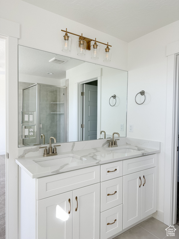 Bathroom featuring vanity, tile patterned floors, and walk in shower