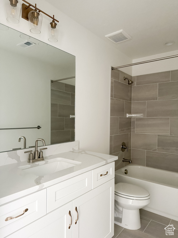 Full bathroom with vanity, toilet, tile patterned floors, and tiled shower / bath