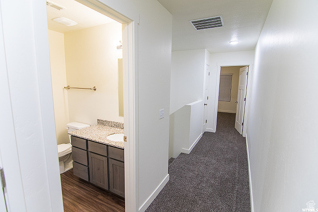 Hall featuring sink and dark wood-type flooring