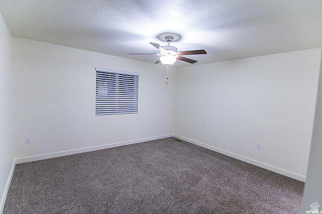 Carpeted spare room with ceiling fan