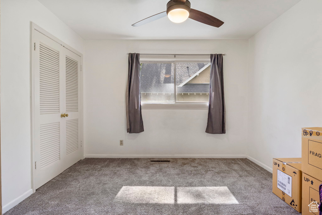 Unfurnished bedroom with a closet, carpet floors, and ceiling fan