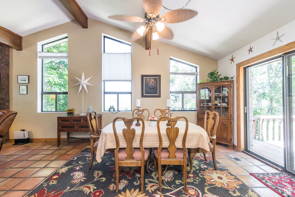 Dining room with tile floors, plenty of natural light, and lofted ceiling with beams