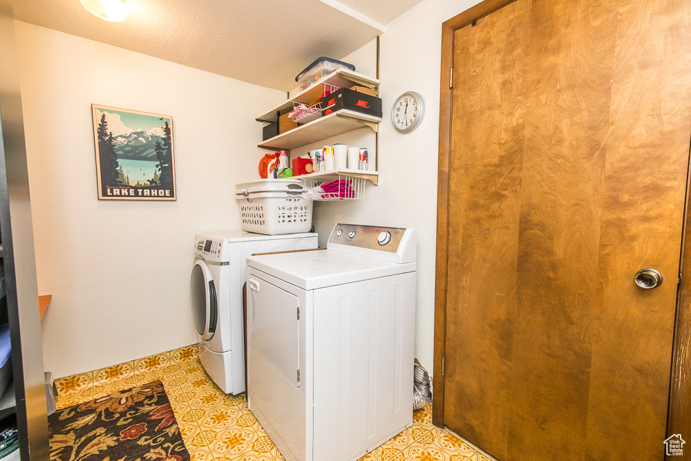 Laundry area featuring washer and clothes dryer and light tile floors