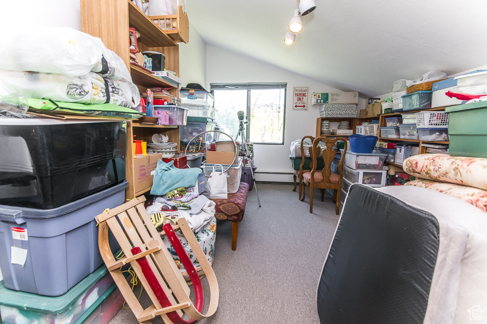 Interior space with vaulted ceiling, baseboard heating, and carpet floors