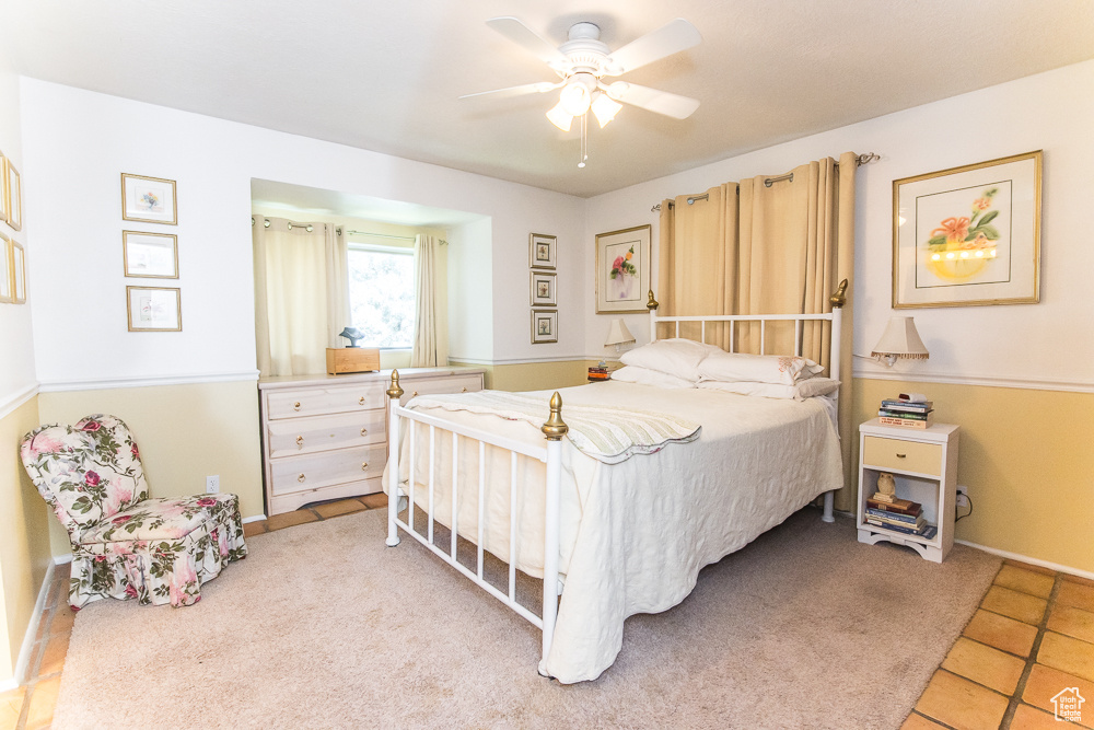 Bedroom with ceiling fan and light tile floors