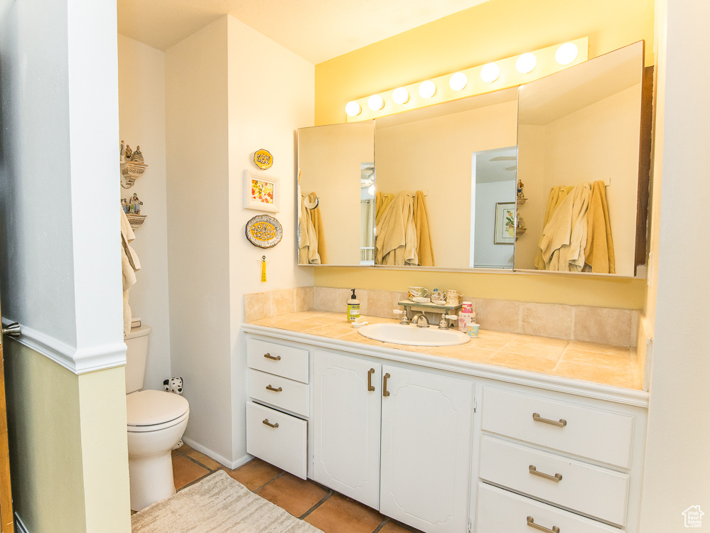 Bathroom featuring toilet, tile floors, and large vanity