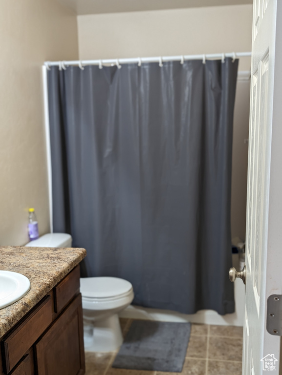 Bathroom with tile flooring, vanity, and toilet