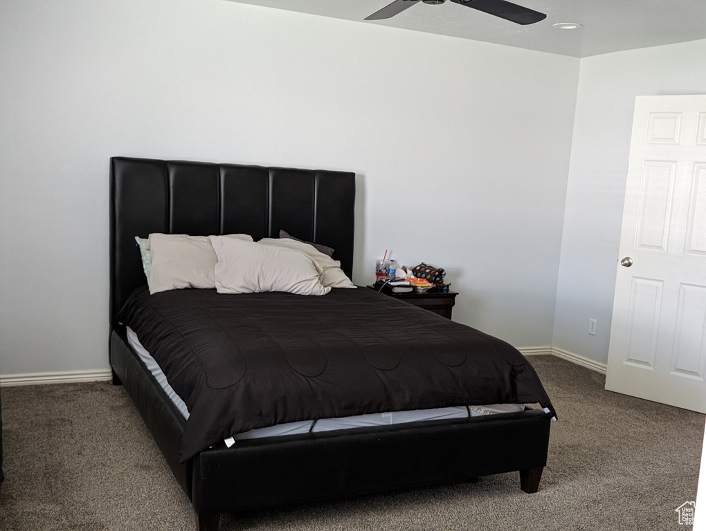 Carpeted bedroom featuring ceiling fan