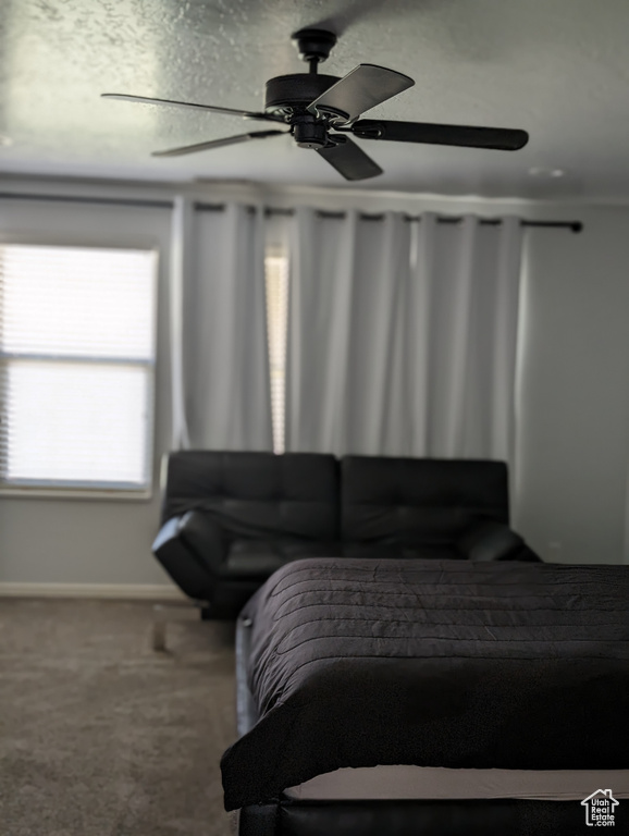 Carpeted bedroom featuring ceiling fan