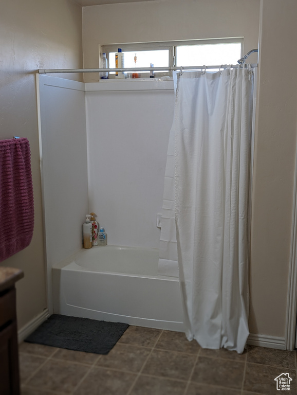 Bathroom featuring shower / bathtub combination with curtain, tile flooring, a healthy amount of sunlight, and vanity