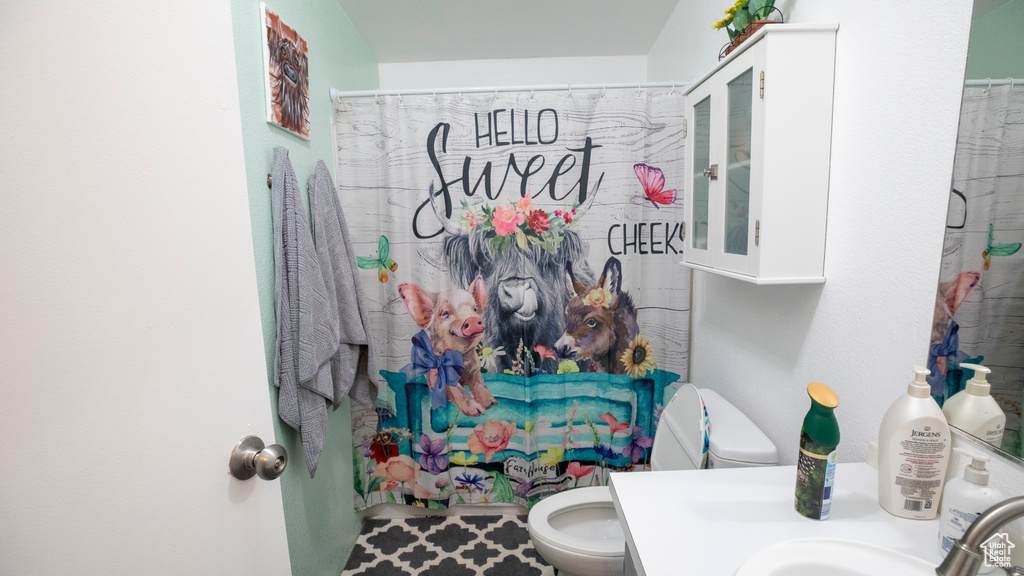 Bathroom featuring large vanity and toilet