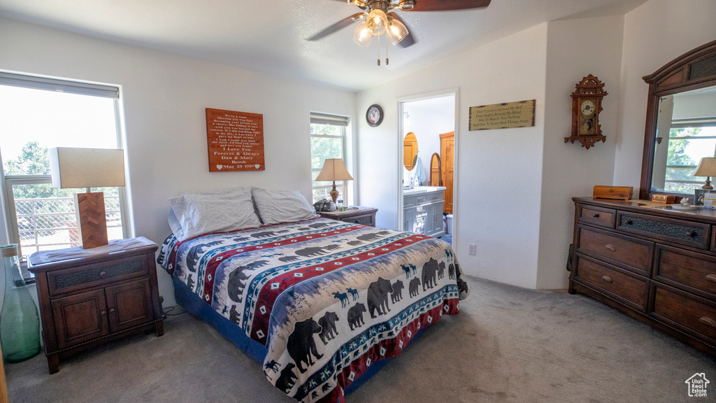 Bedroom with lofted ceiling, carpet floors, multiple windows, and ceiling fan