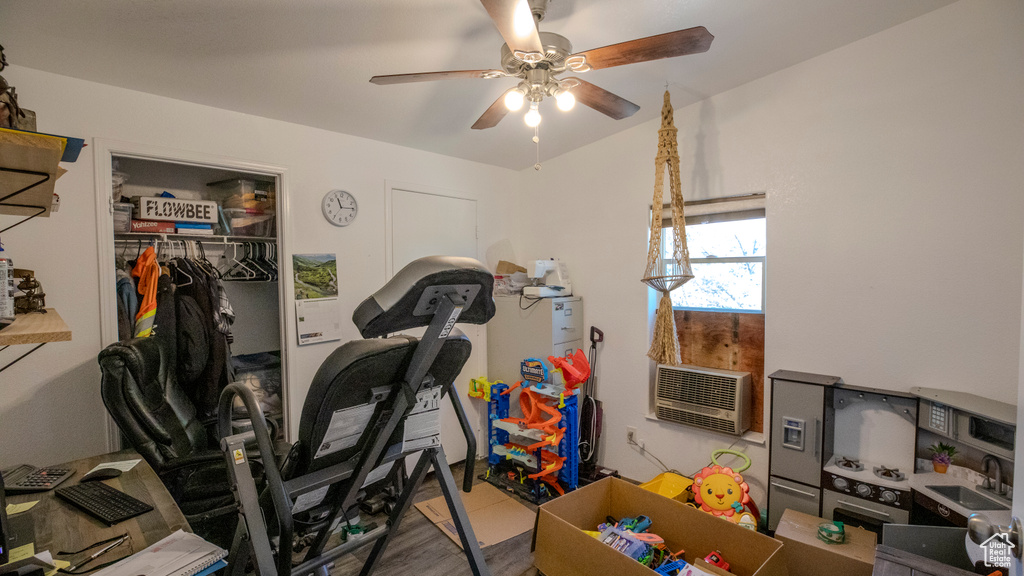 Exercise room with hardwood / wood-style floors, sink, and ceiling fan