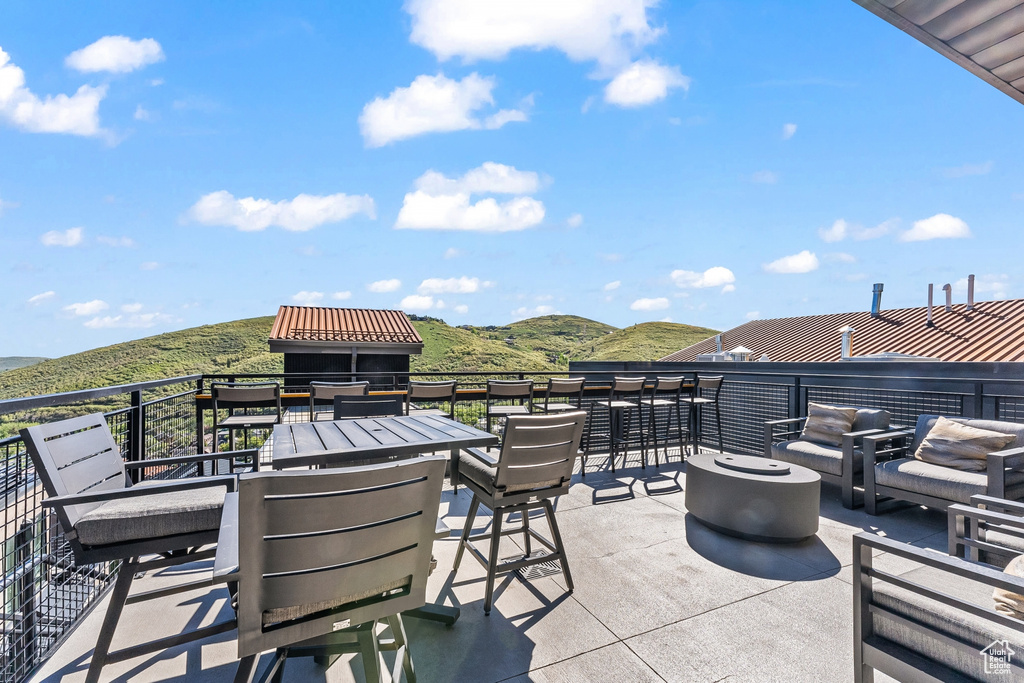 View of patio with a mountain view and a balcony