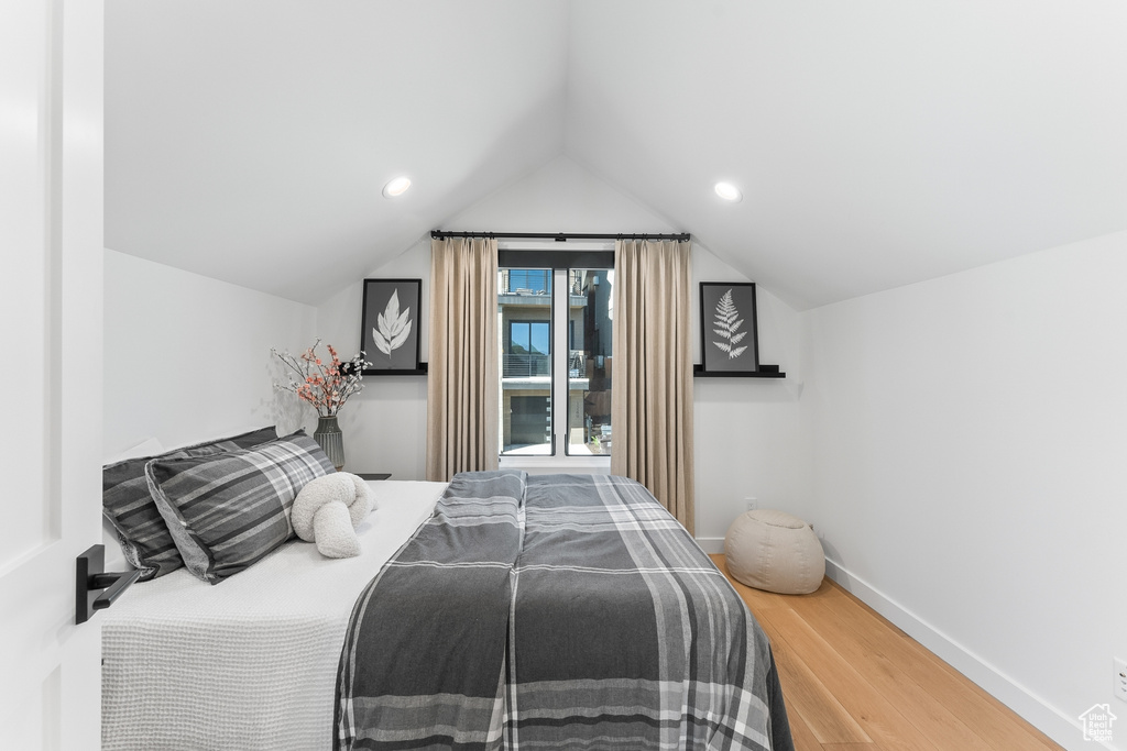 Bedroom with hardwood / wood-style flooring and lofted ceiling