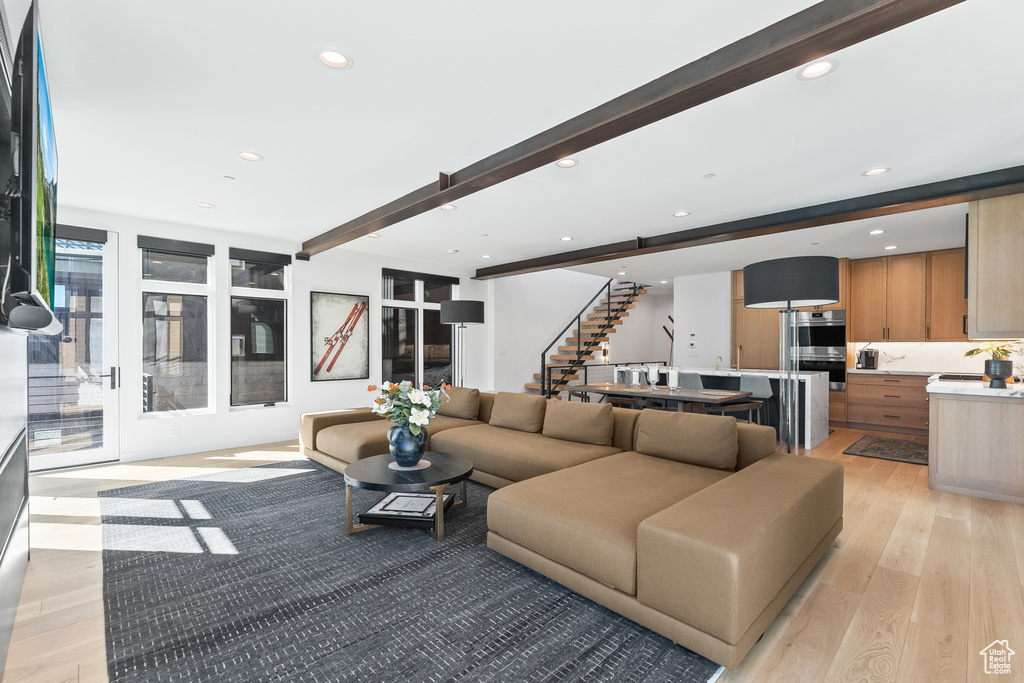 Living room featuring beamed ceiling and light hardwood / wood-style flooring