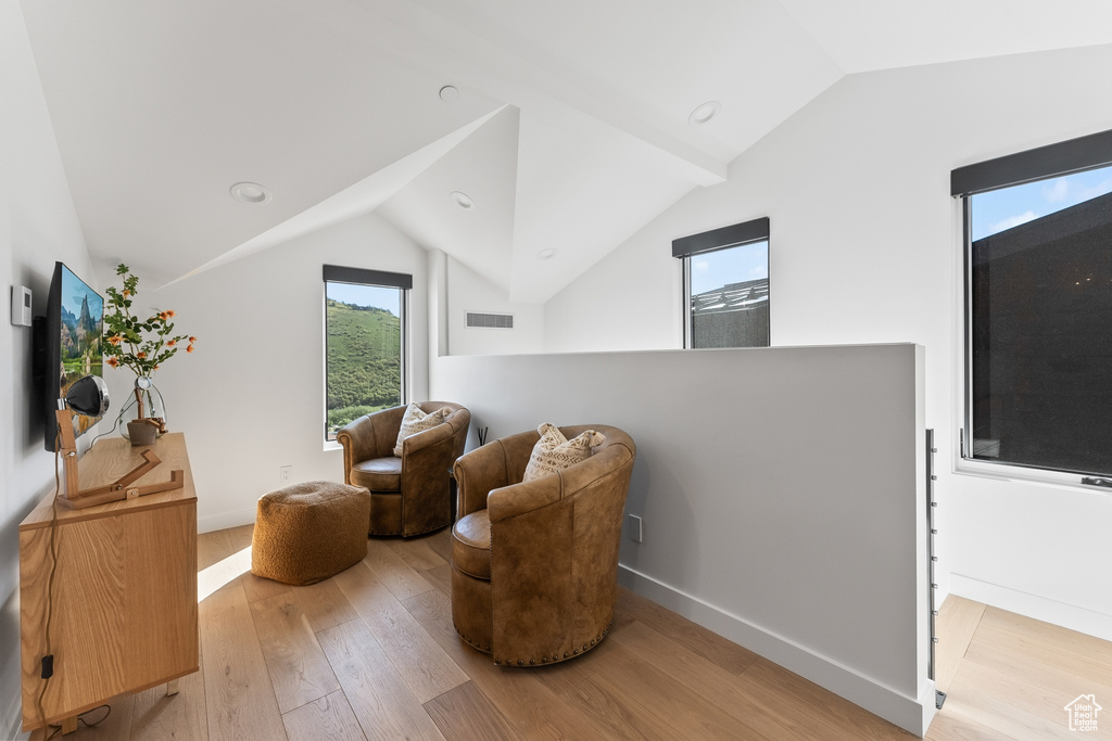 Sitting room with lofted ceiling and wood-type flooring