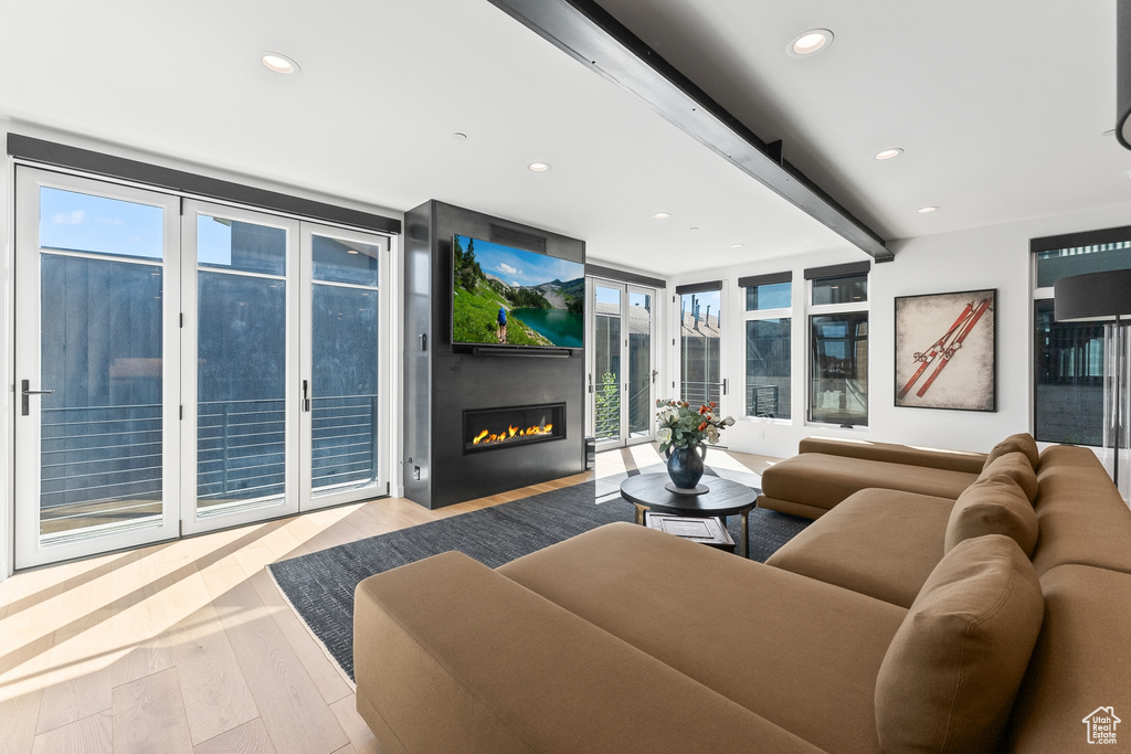 Living room with a wealth of natural light, expansive windows, and light wood-type flooring